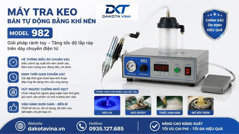 Máy tra keo bán tự động model 982 dùng khí nén có vỏ kim loại màu xanh mỏ vịt. Mặt trước máy có đồng hồ đo áp suất, các nút cài đặt và màn hình LED. Bên cạnh máy là một giá đỡ treo ống chứa keo trong suốt và một chiếc bàn đạp chân màu đen